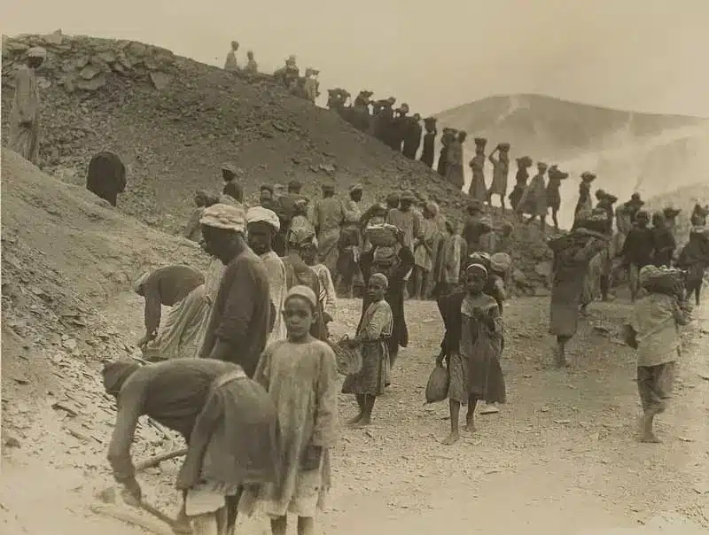 Image montrant des ouvriers y compris des enfants en train de désensabler un site archéologique.